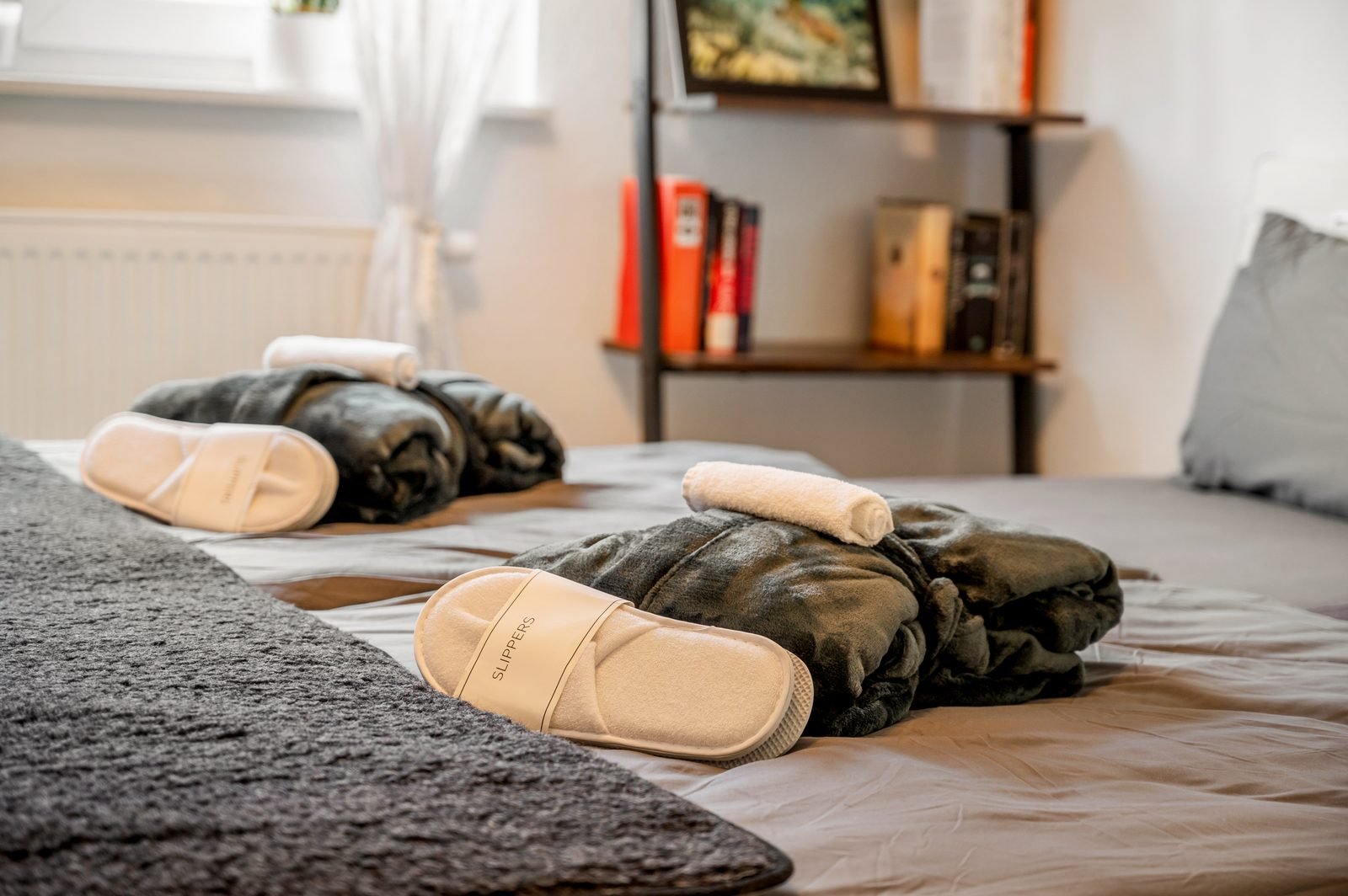 Bademantel, Slipper und Handtuch auf dem Bett