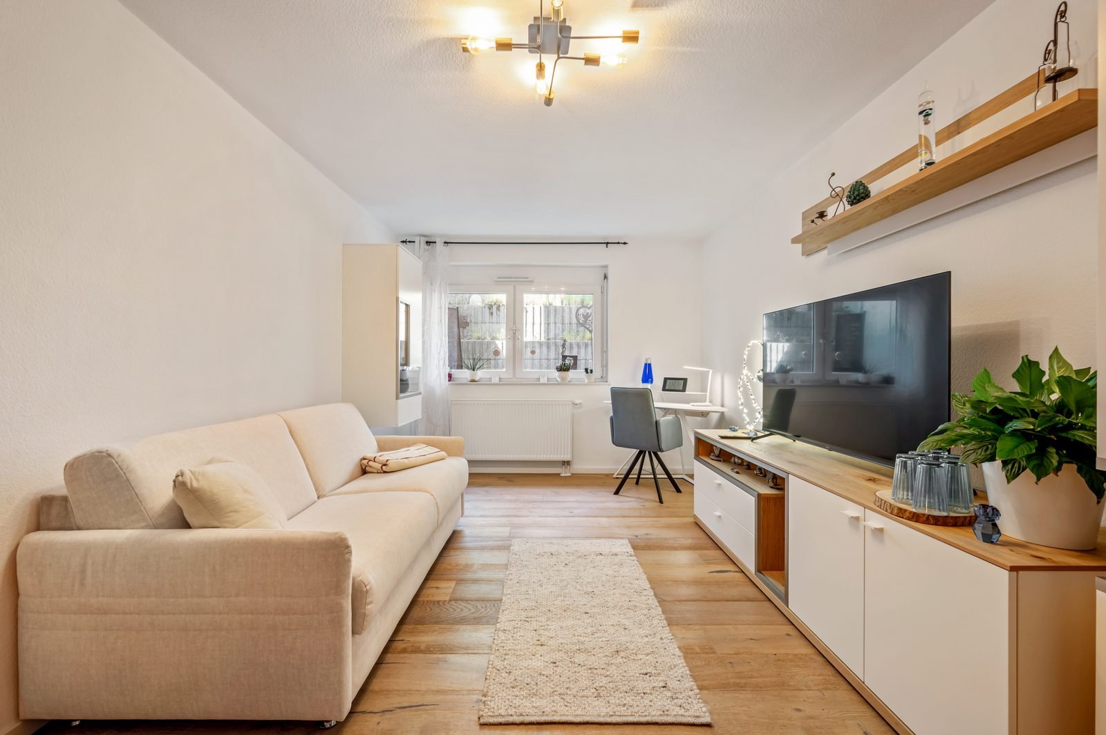 Wohnbereich mit Sofa, TV und Arbeitsplatz